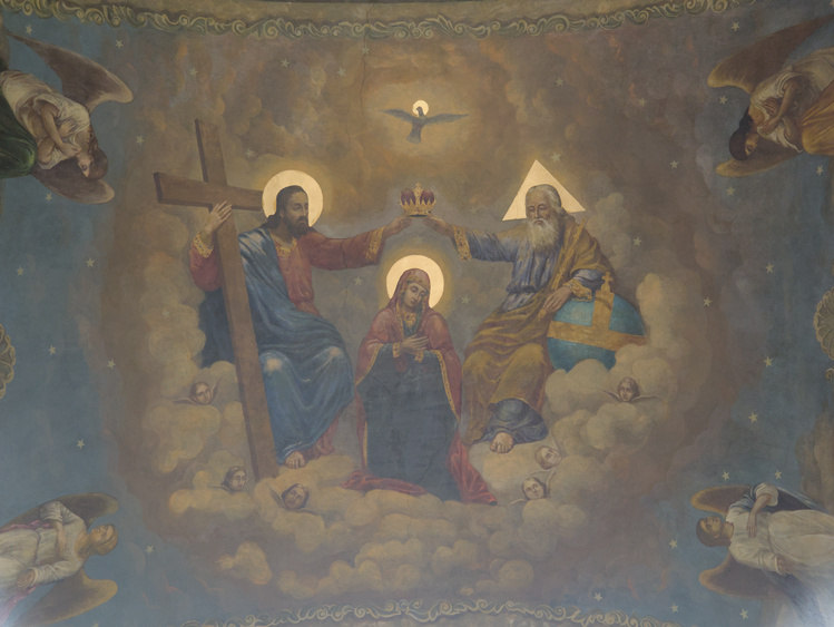 Pintura, donde están Jesús, Dios y el Espíritu Santo coronando a María. Todos tienen un halo dorado sobre su cabeza, pero el de Dios es triangular.
