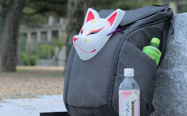Kitsune mask attached to a backpack.