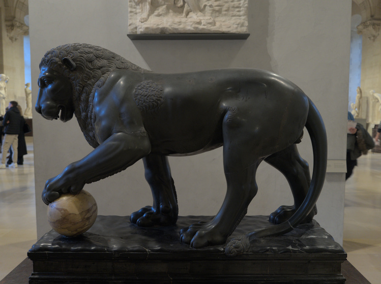 Escultura de un León con una pelota bajo su garra.
