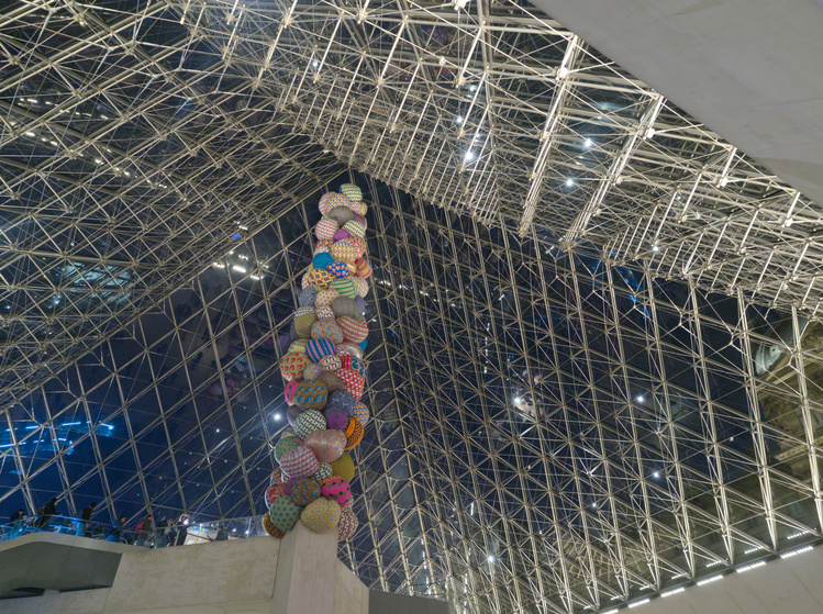 La pirámide de cristal del Louvre con globos colgando de su techo.
