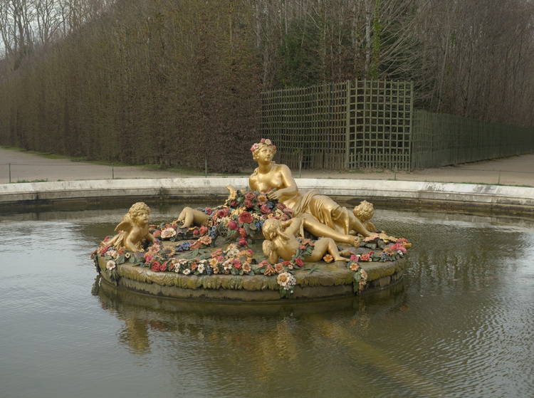 Fuente de agua con esculturas en dorado en el centro.
