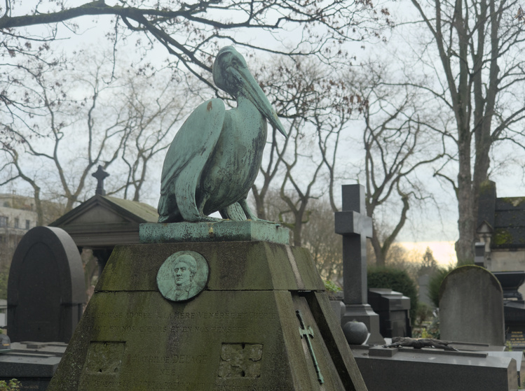 Tumba con una estatua de un pelícano.
