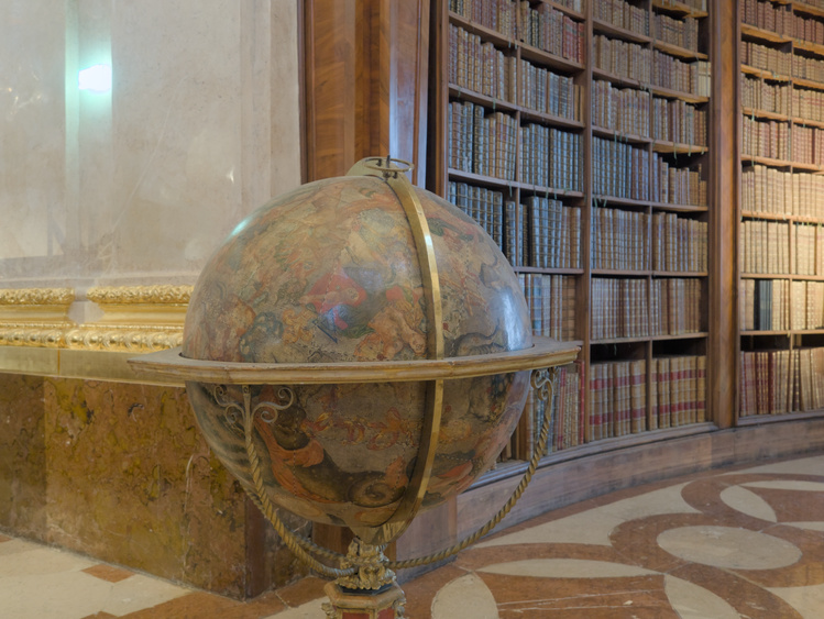 Globo terráqueo con un estante de fondo.
