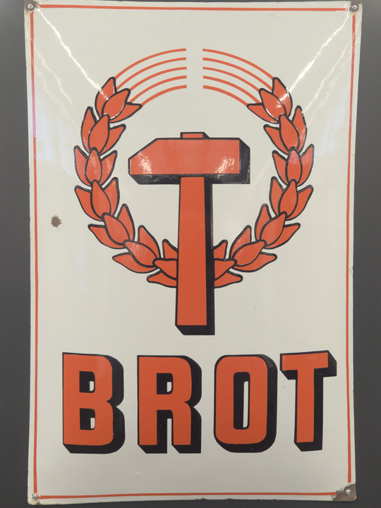 Ilustración de un martillo sobre plantas de trigo reemplazando la hoz.
