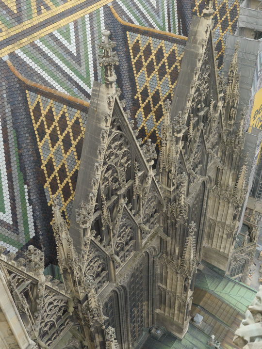Vista desde arriba de la catedral, donde se aprecian sus tejas de colores y sus torres y puertas de estilo gótico.
